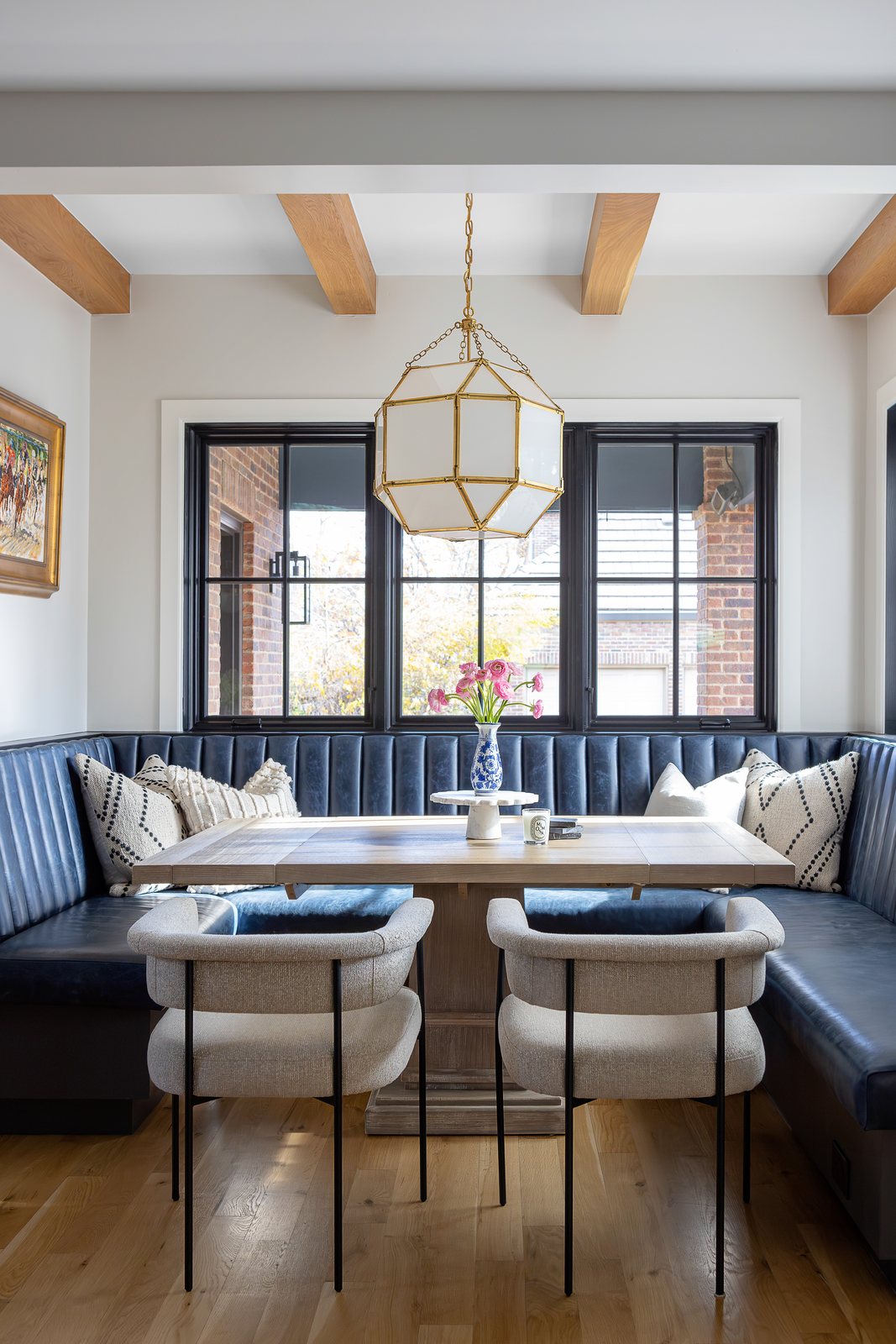 Vertical view of the breakfast nook banquette, oak table and brass lantern pendant in the Bonnie Brae remodel, Denver.