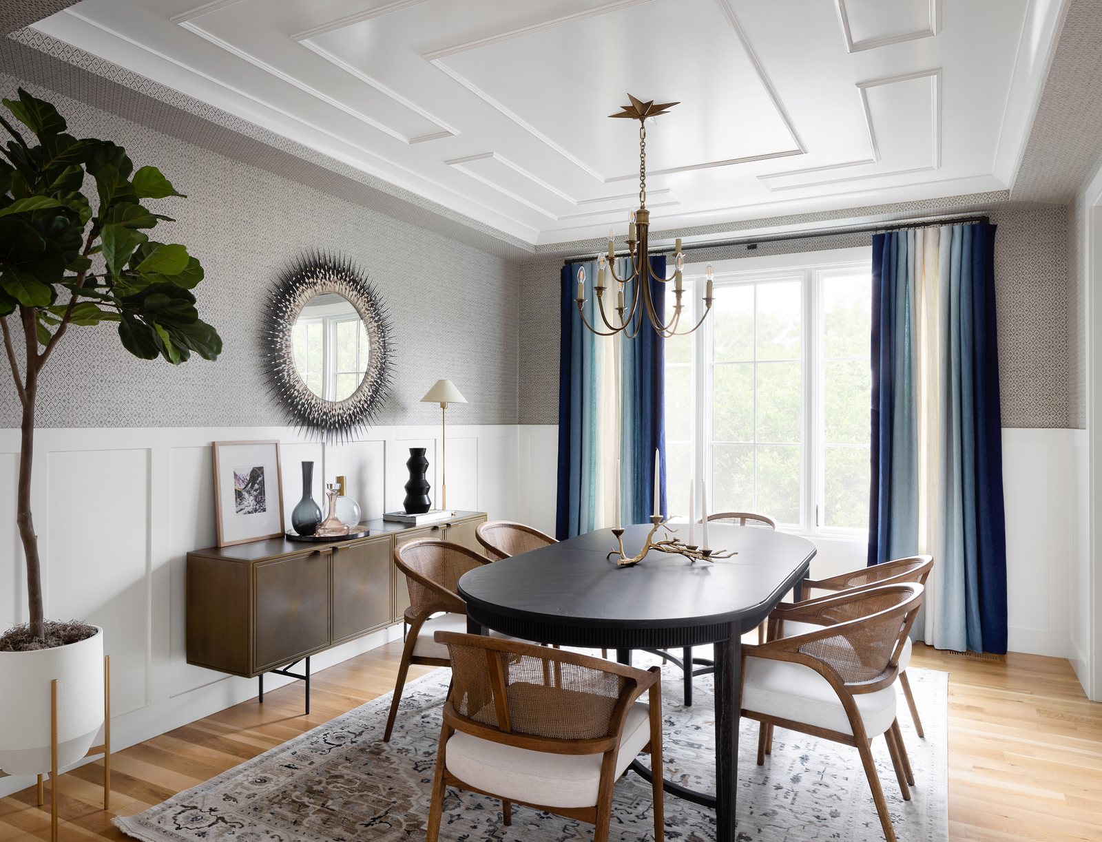 Dining room with cane-back chairs, a black oval table, blue ombre drapes and a paneled ceiling in the Bonnie Brae remodel, Denver.