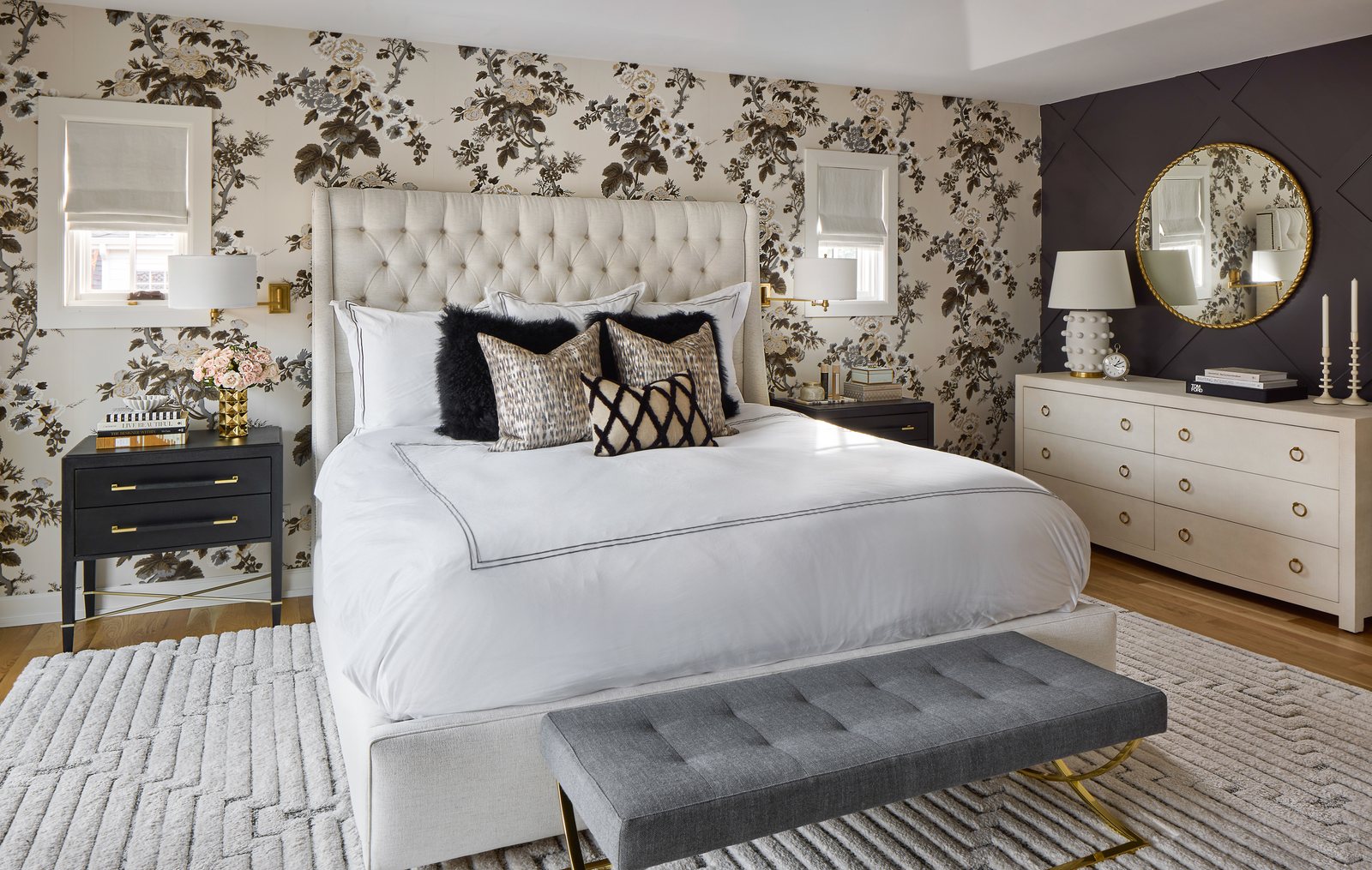 Primary bedroom with a tufted headboard, black-and-cream floral wallpaper and a charcoal accent wall in the Bonnie Brae remodel, Denver.