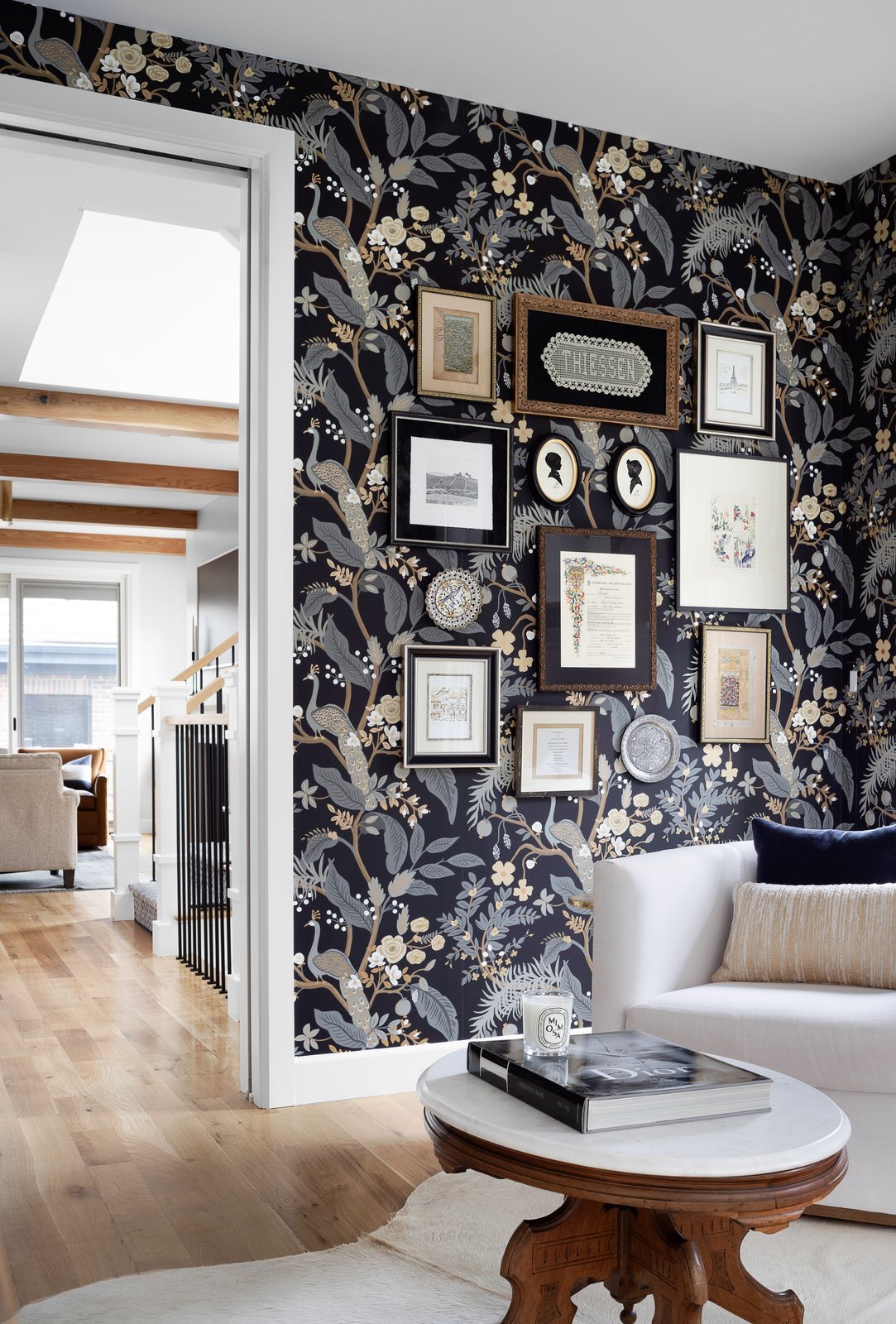 Vintage frame gallery wall on dark botanical wallpaper beside the sofa in the Bonnie Brae sitting room, Denver.
