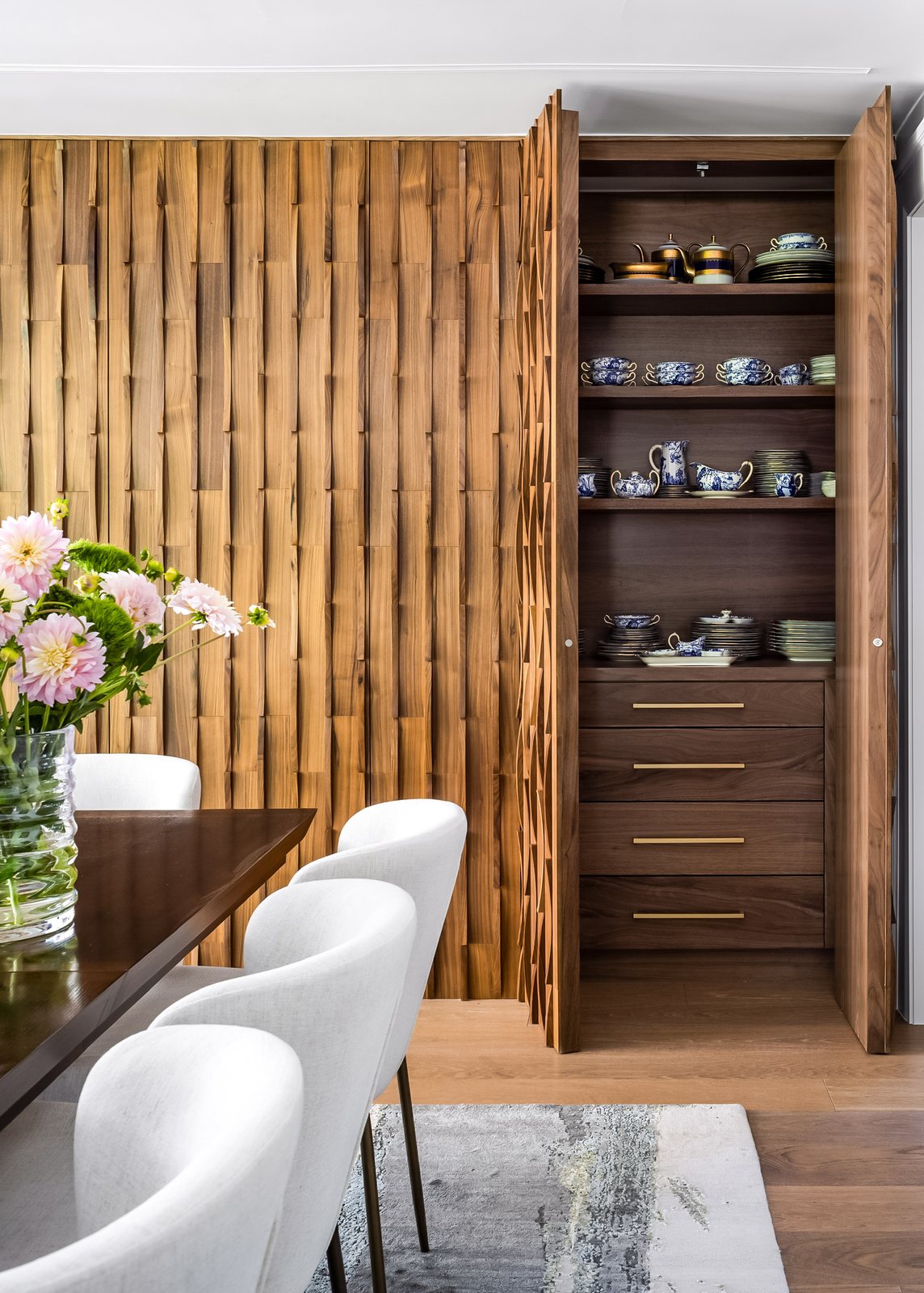 Open wood cabinet displaying china beside the dining table in the Greenwood Village whole-home remodel.