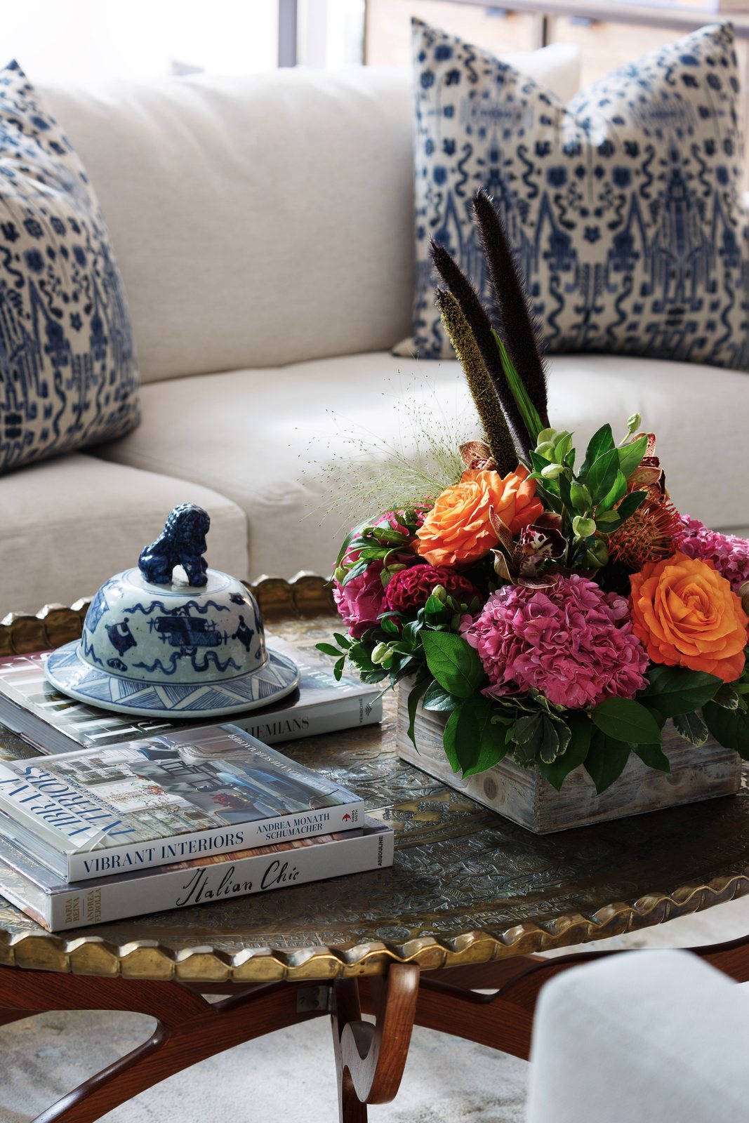 Brass tray coffee table styled with peonies, books and blue-and-white porcelain in the Greenwood Village whole-home remodel living room.