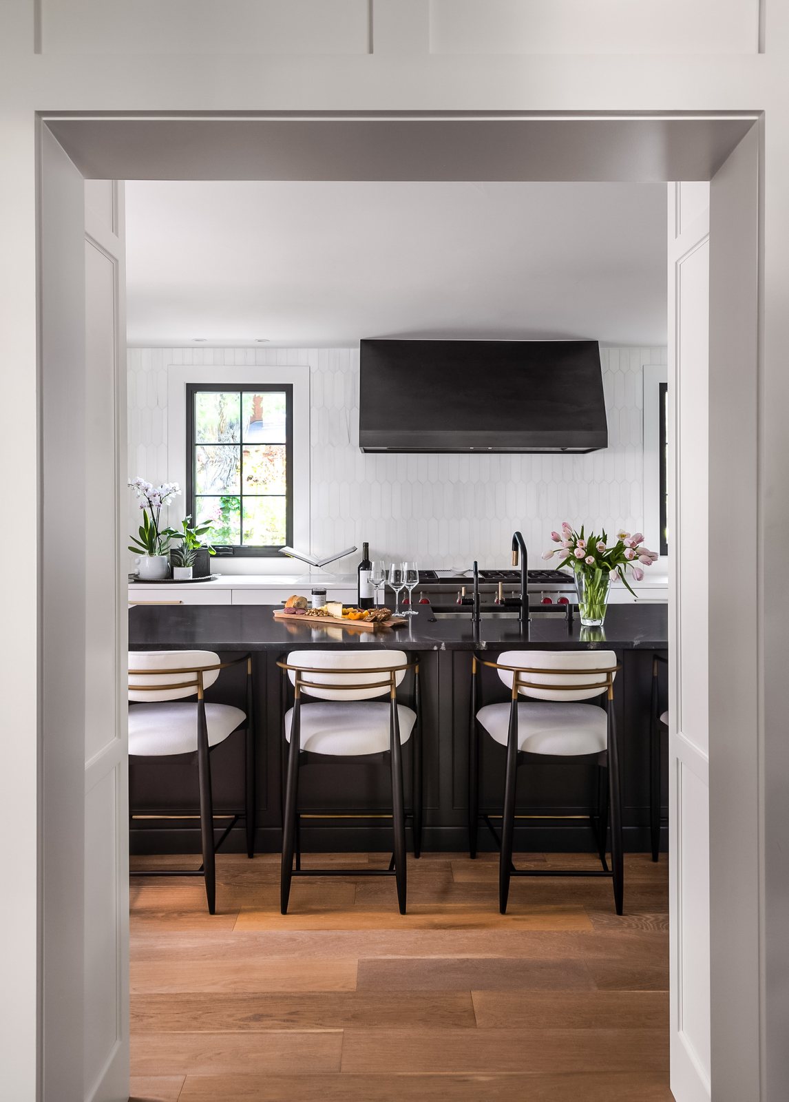 View through a cased opening to the kitchen island seating in the Greenwood Village whole-home remodel.