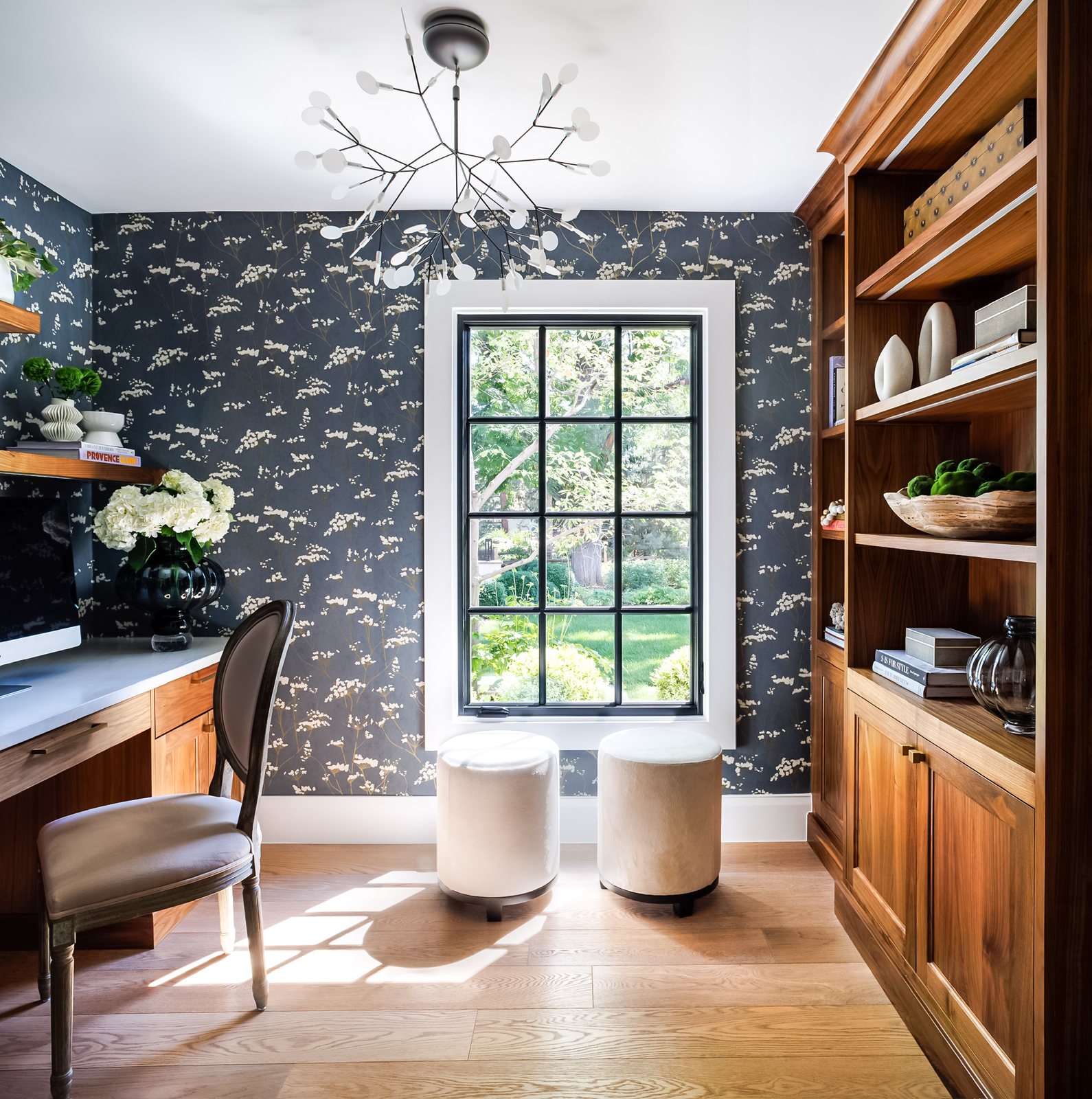 Home office with navy botanical wallpaper, walnut built-in shelving and a branch chandelier in the Greenwood Village whole-home remodel.