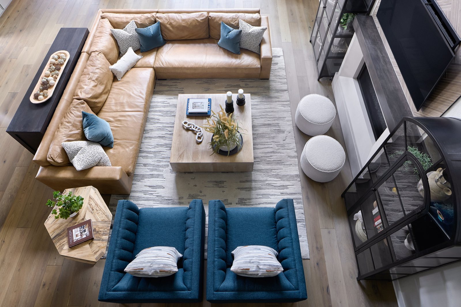 Overhead view from the balcony of the leather sectional, blue armchairs and layered rug in The Canyons great room, Castle Pines.