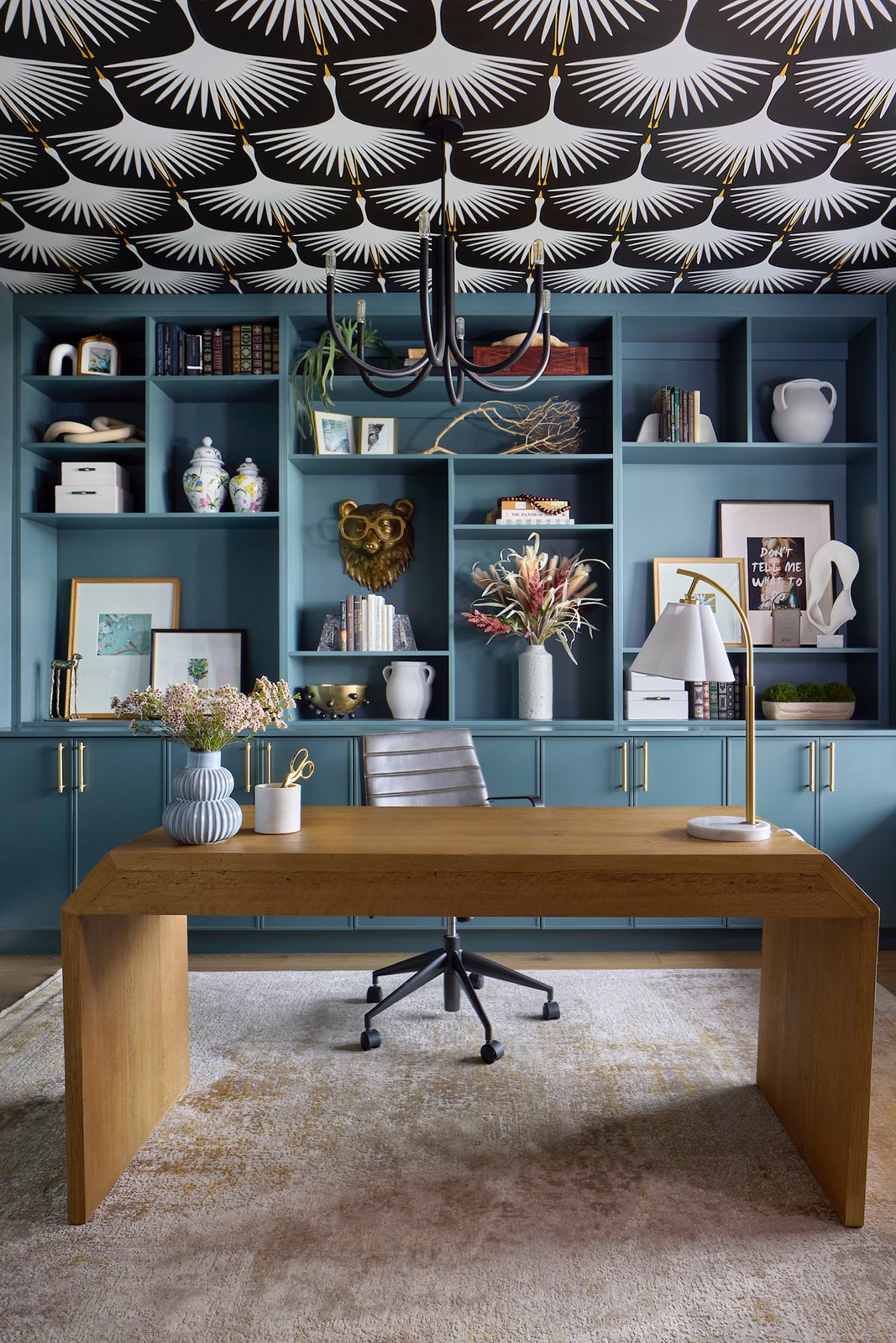 Home office with slate-blue built-ins, an oak waterfall desk and crane-patterned wallpapered ceiling in The Canyons new build, Castle Pines.