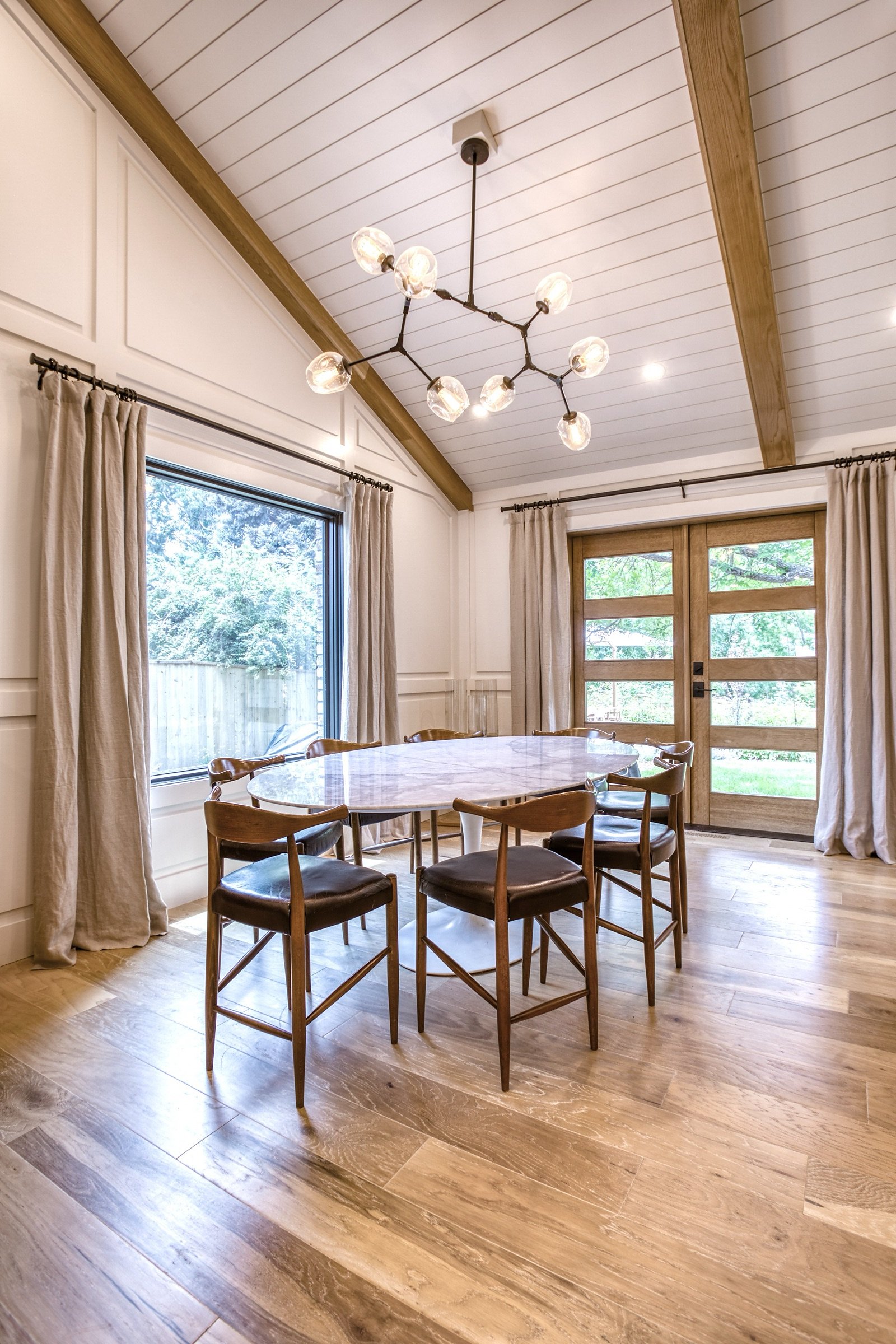 Breakfast nook with round table and mid-century chairs by the window, Fulton Street whole house renovation in Greenwood Village