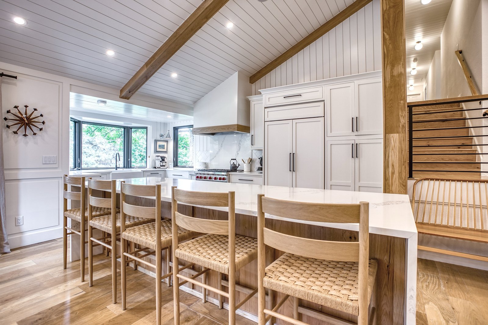 Kitchen island seating with woven barstools beneath the opened ceiling, Fulton Street whole house renovation in Greenwood Village