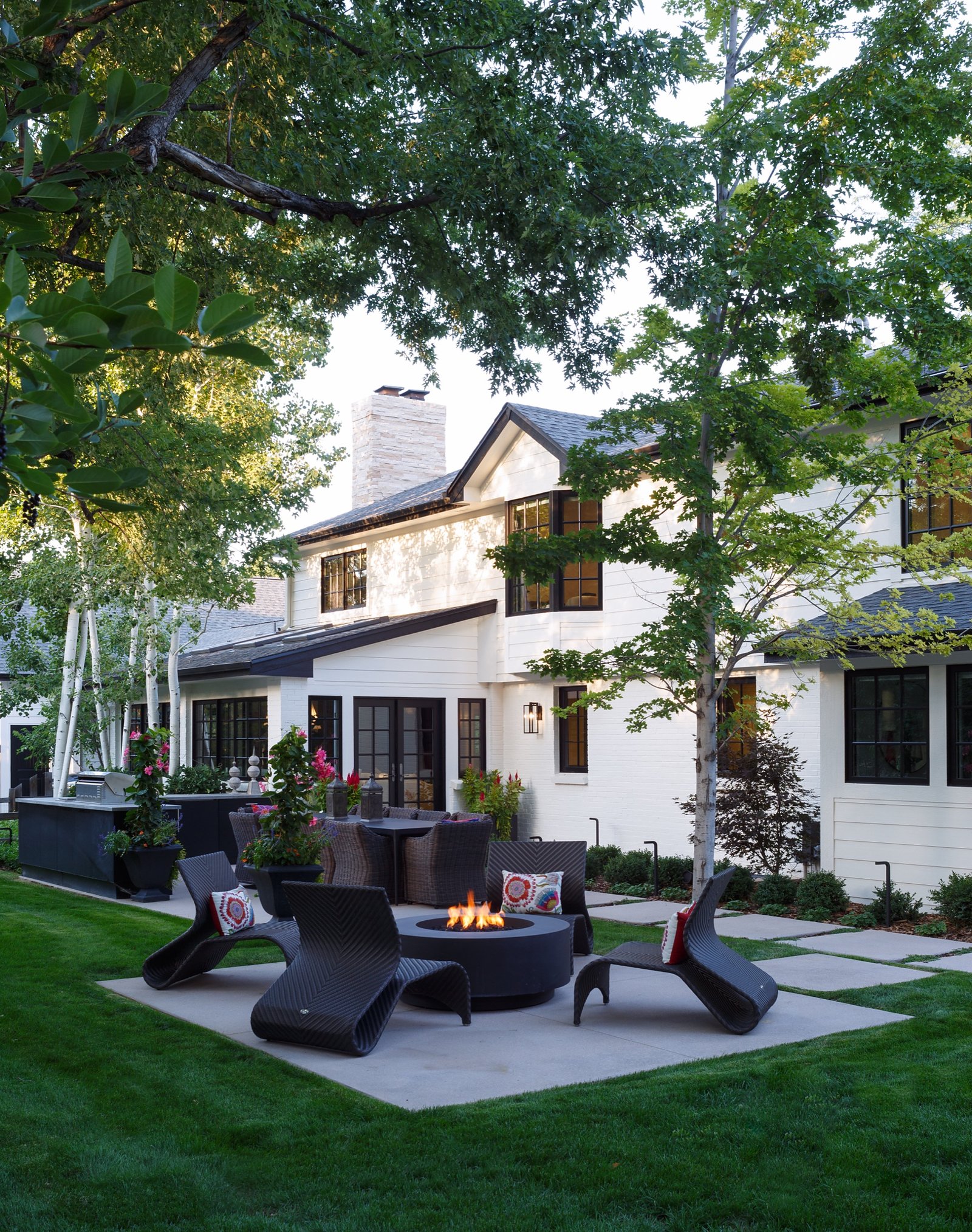 White modern farmhouse exterior with landscaped patio from the Greenwood Village whole home renovation by E+E