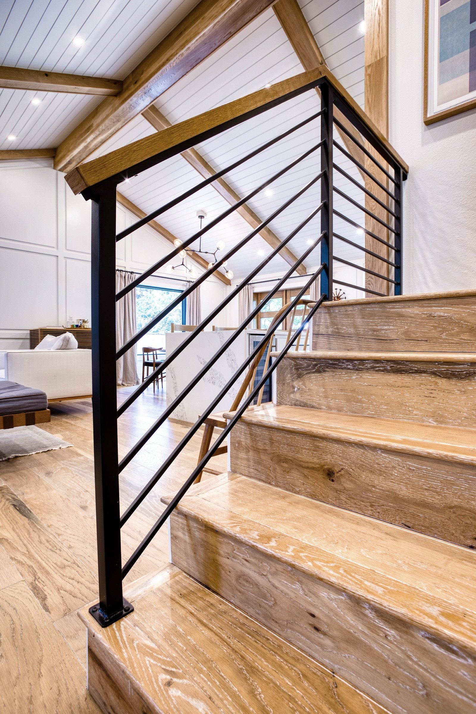 Staircase with horizontal iron rail and white oak treads, Fulton Street whole house renovation in Greenwood Village
