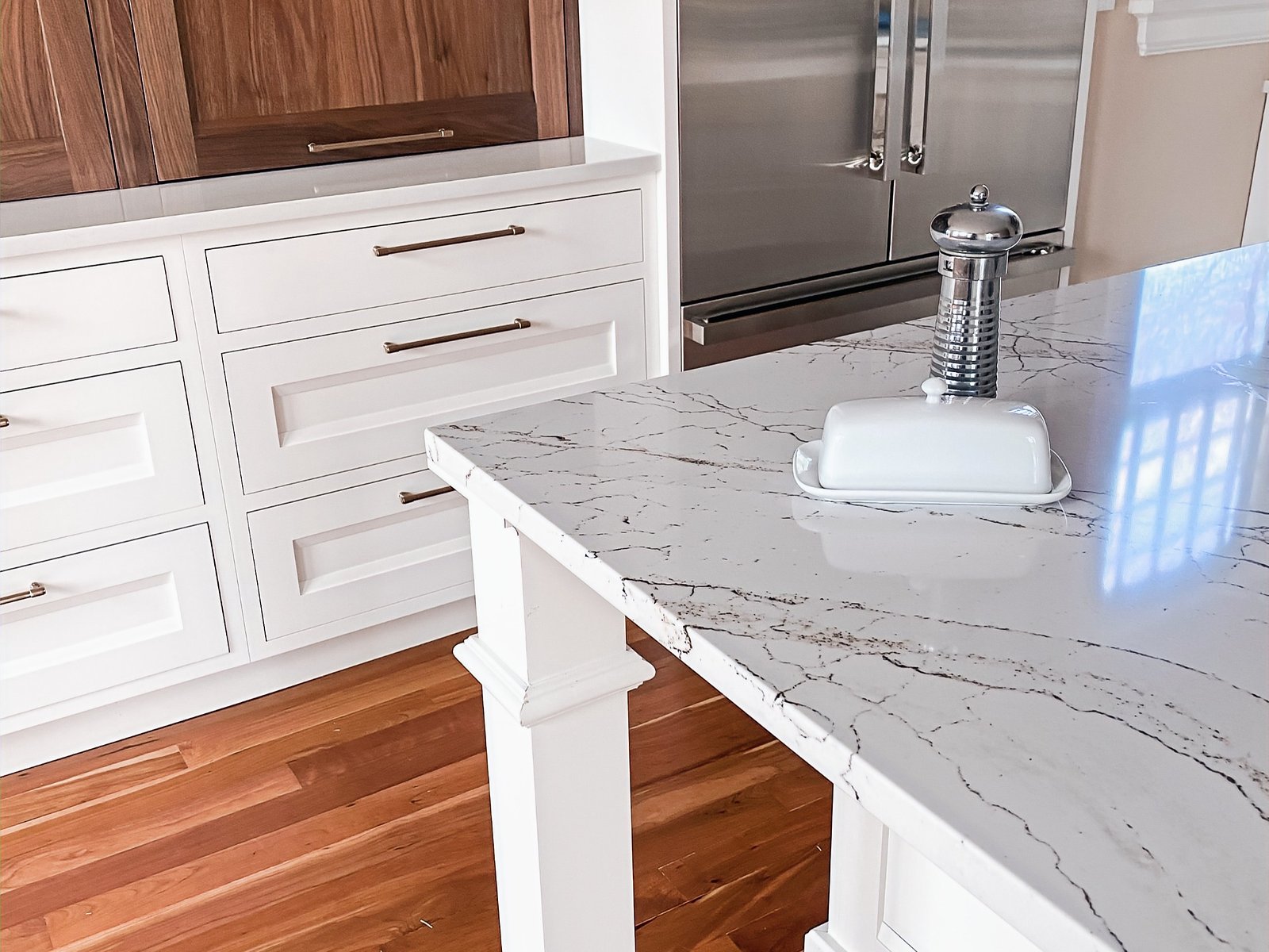 Island with marble-look quartz and warm walnut base, historic Colorado Springs kitchen remodel