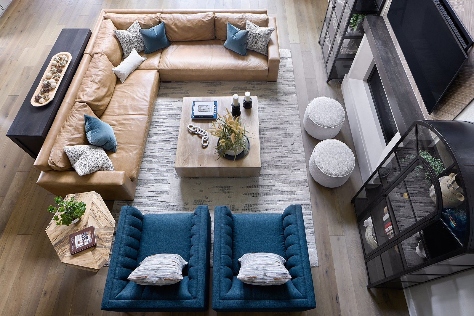 Overhead view of The Canyons living room with tan leather sectional, blue lounge chairs, and layered rug