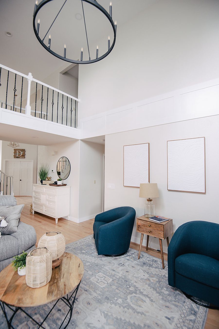 Family room seating area with round wood side tables and soft blue rug, Stonegate main floor renovation in Parker, Colorado