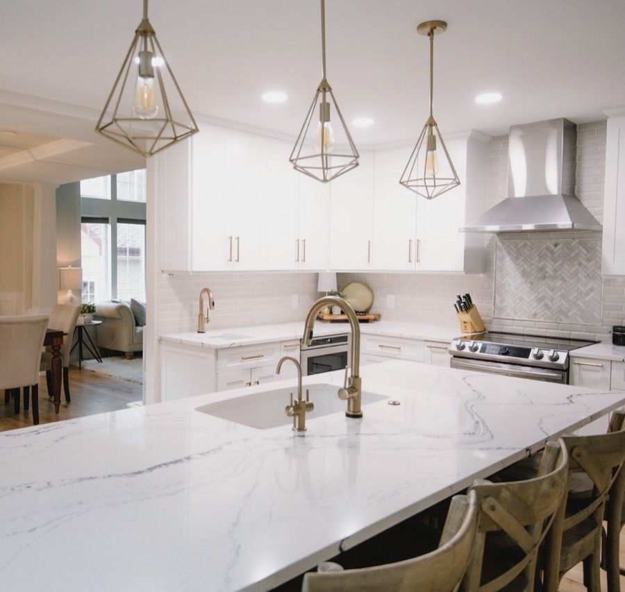 Geometric brass pendants over the marble-look island, Stonegate main floor renovation in Parker, Colorado