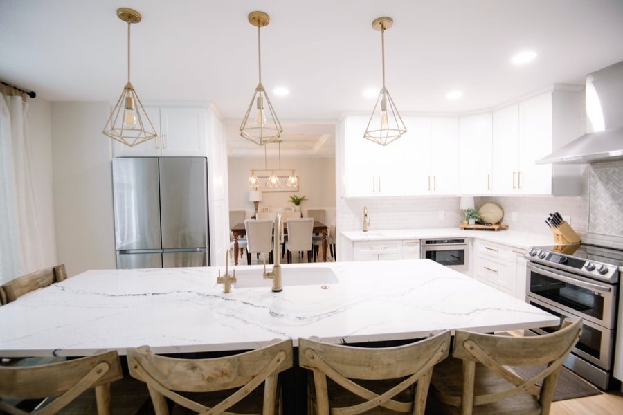 Open kitchen and dining with brass lanterns and creamy white palette, Stonegate main floor renovation in Parker, Colorado