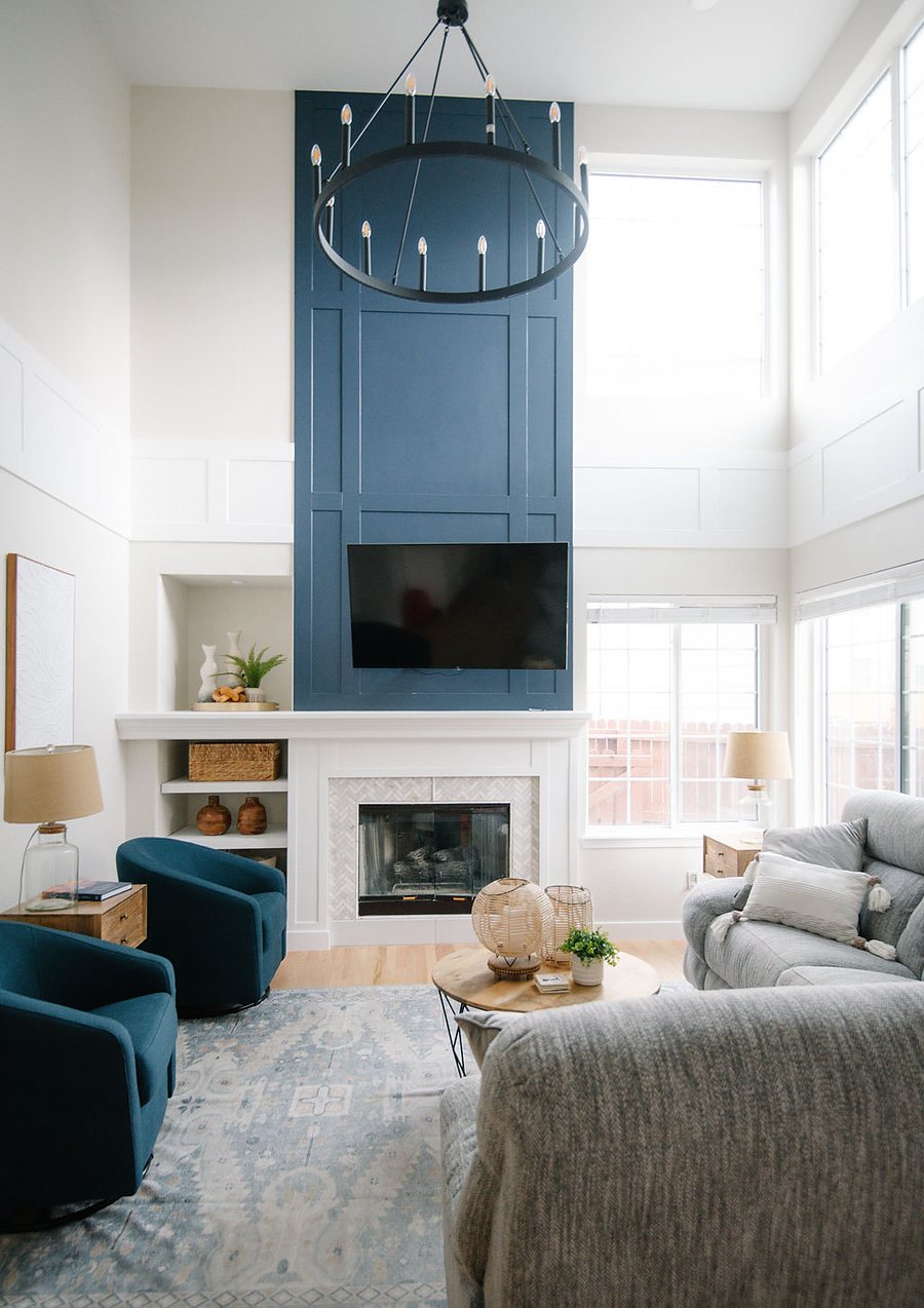 Two-story family room with navy shiplap fireplace, round chandelier, and teal swivel chairs, Stonegate main floor renovation in Parker, Colorado