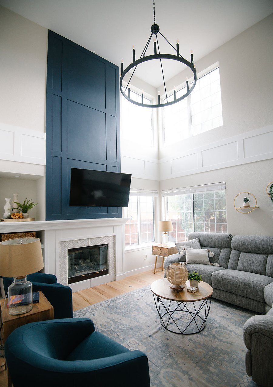 Full-height navy fireplace wall with white mantle in the double-height living room, Stonegate main floor renovation in Parker, Colorado